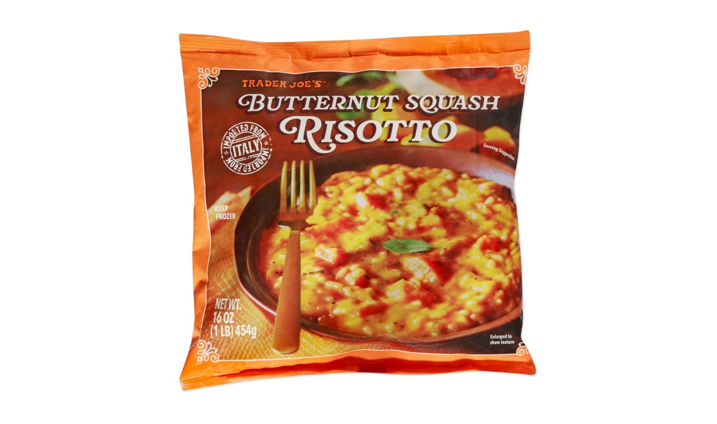 A bag of Trader Joe’s Butternut Squash Risotto, featuring a photo of creamy risotto with orange and yellow tones on a plate, a fork, and product details on the orange packaging.