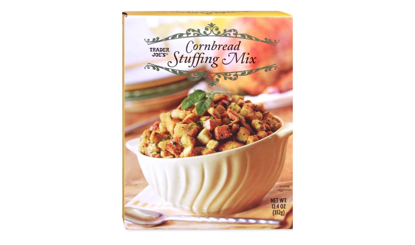 Box of Trader Joe's Cornbread Stuffing Mix featuring a bowl filled with golden, cubed stuffing on the front, garnished with a sprig of herbs, and a decorative label at the top.