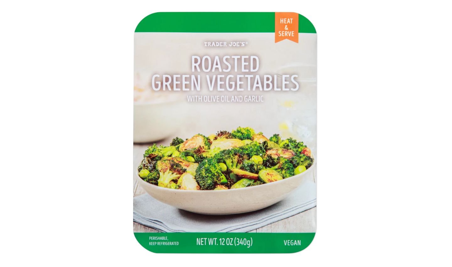 Trader Joe’s package of roasted green vegetables with olive oil and garlic. The front shows a bowl filled with roasted broccoli, brussels sprouts, and other greens. Text indicates it is vegan and ready to heat and serve.
