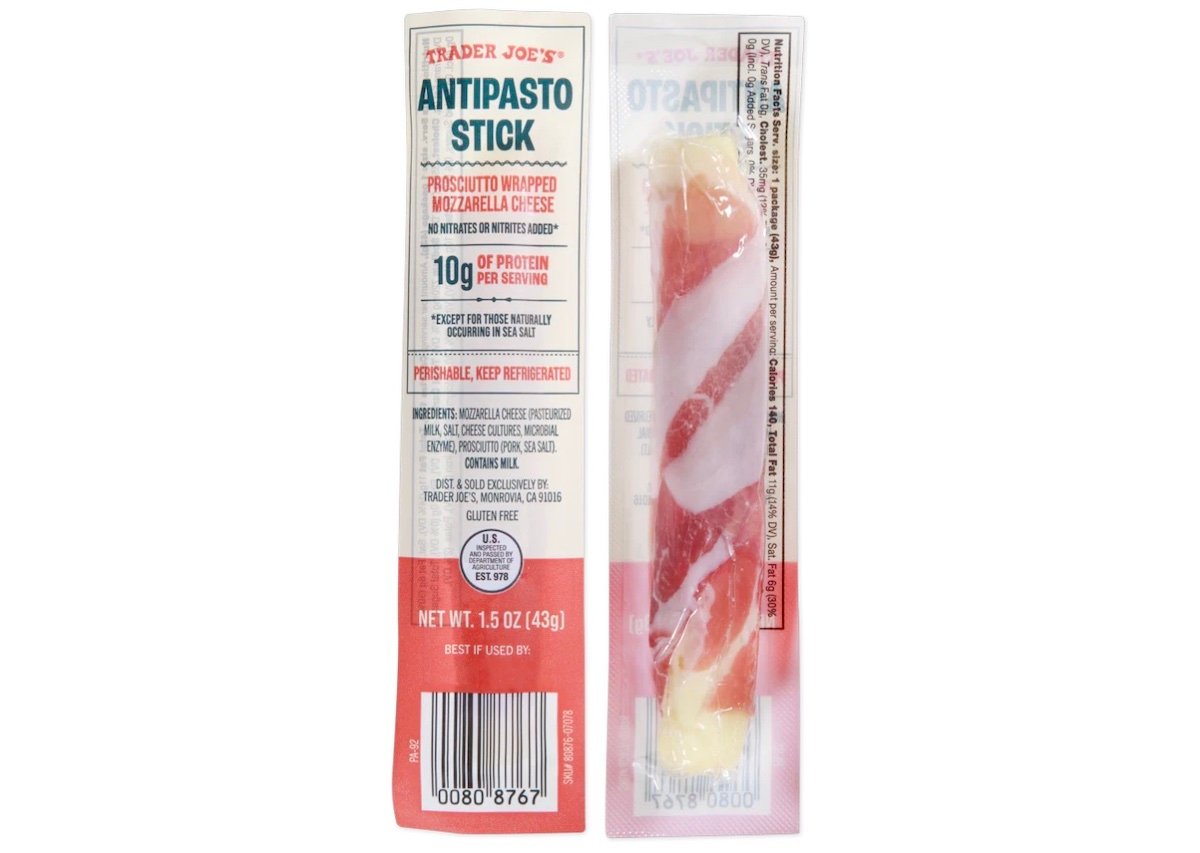 A Trader Joe's Antipasto Stick package showing a prosciutto-wrapped mozzarella cheese stick in clear plastic. The label highlights 10g of protein per serving and instructs to keep refrigerated.