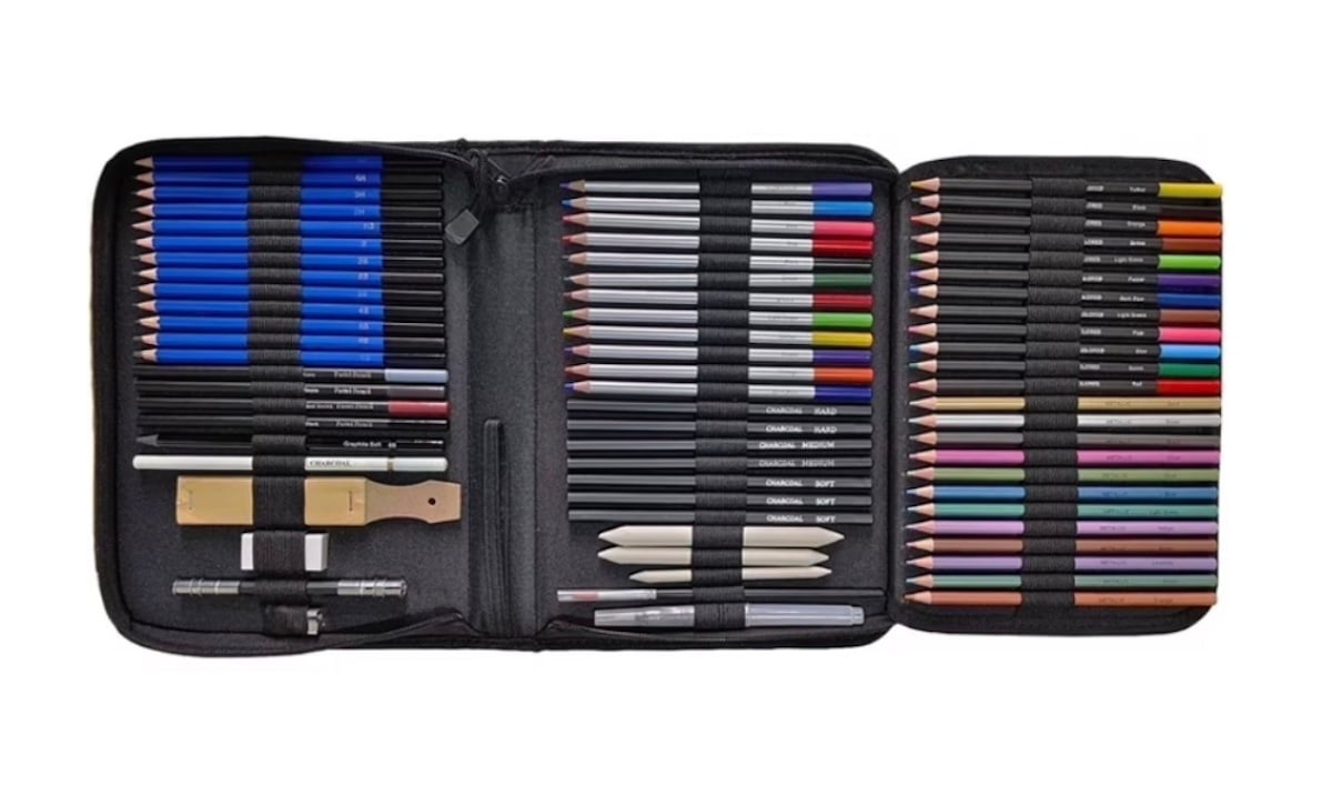 A black zippered art supply case open to show neatly arranged colored pencils, graphite pencils, pens, erasers, sharpeners, blending stumps, and brushes in elastic holders on both sides.