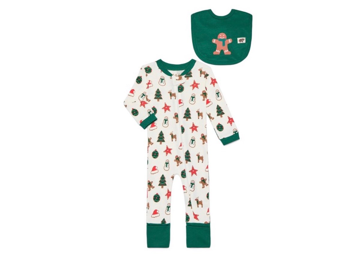 A baby pajama set with festive Christmas prints, including trees, stars, snowmen, and gingerbread men. The set includes a long-sleeve, footless onesie and a matching green bib with a gingerbread man design.