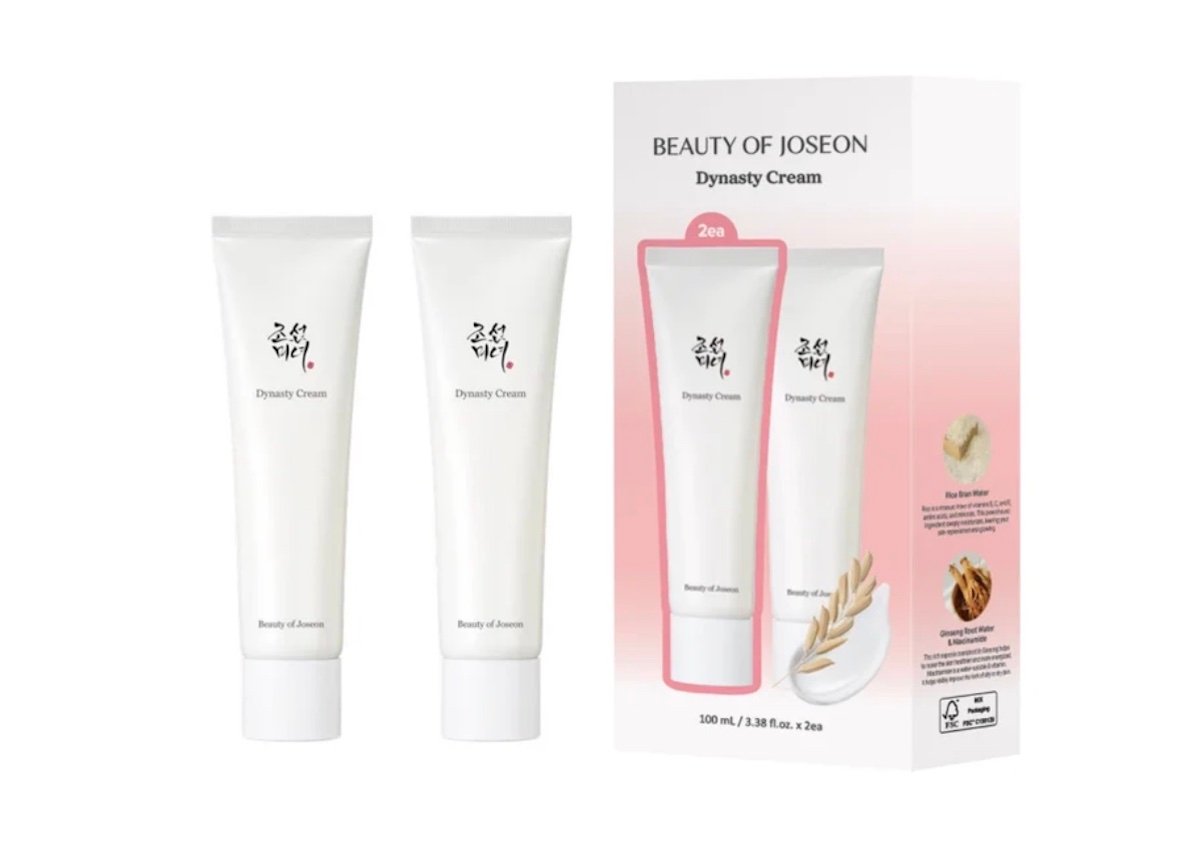 Two white tubes of Beauty of Joseon Dynasty Cream stand next to their packaging box, which displays images of the tubes, product information, and decorative graphics.