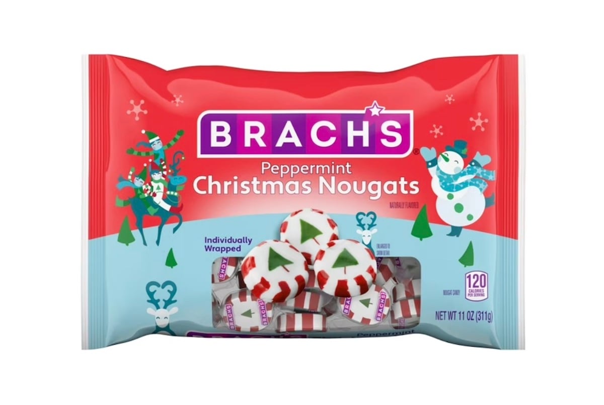 A red and blue bag of Brach's Peppermint Christmas Nougats featuring holiday designs, with individually wrapped candies decorated with green Christmas trees and peppermint stripes visible through a clear window.