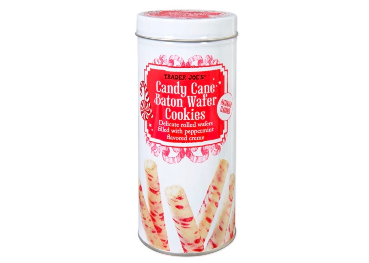 A tall cylindrical tin of Trader Joe's Candy Cane Baton Wafer Cookies, featuring an image of rolled wafer cookies with peppermint creme and red peppermint swirl decorations on a white background.
