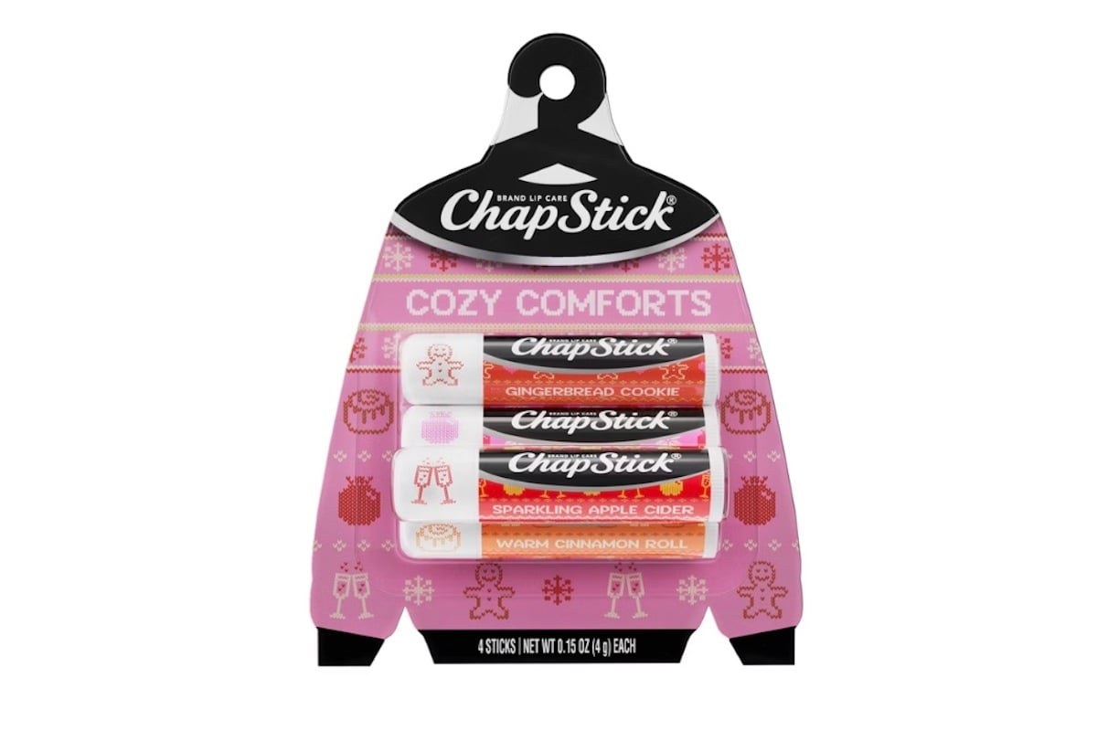 A package of ChapStick Cozy Comforts lip balm featuring four flavors: Gingerbread Cookie, Holiday Cocoa, Sparkling Apple Cider, and Warm Cinnamon Roll, with festive holiday-themed packaging.