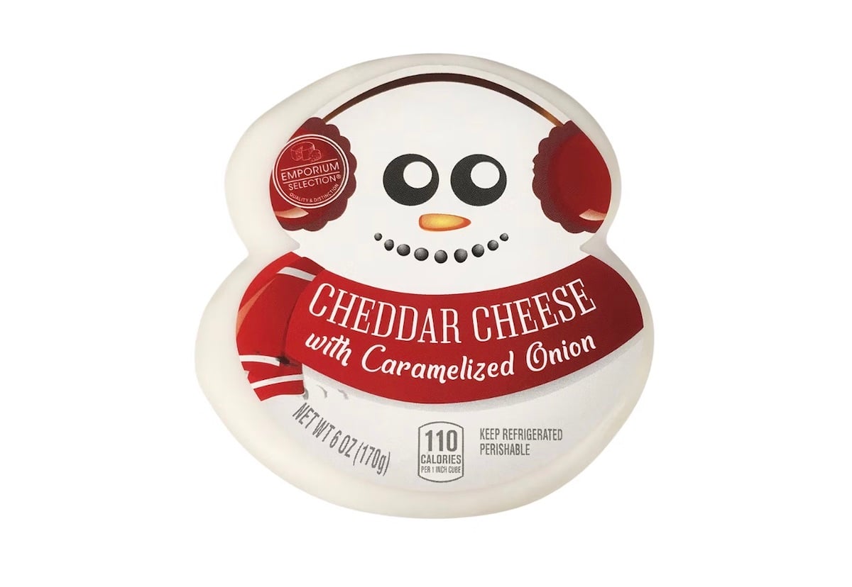 A round package of cheddar cheese with caramelized onion, designed to look like a snowman wearing earmuffs and a scarf. The label reads “CHEDDAR CHEESE with Caramelized Onion.”