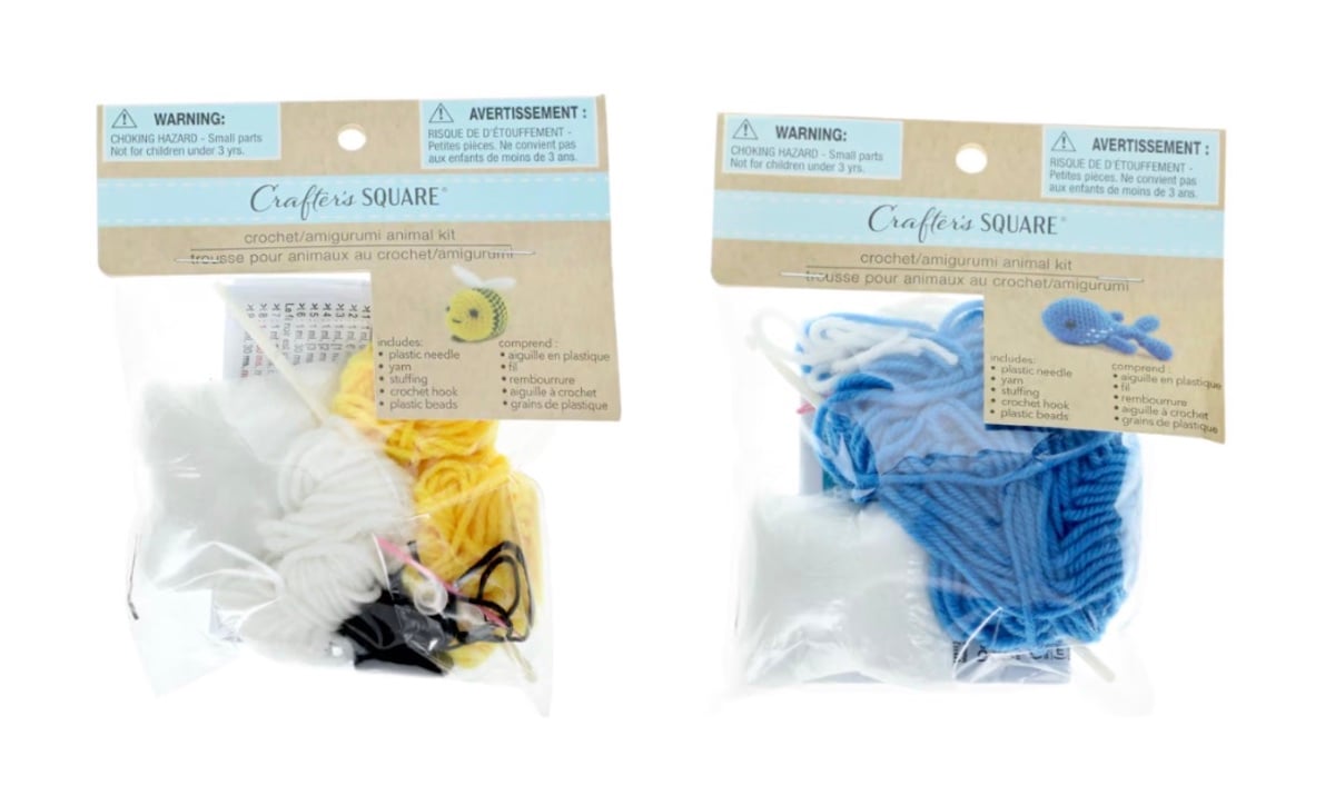 Two Crafter’s Square crochet amigurumi animal kits in clear bags, one with yellow and white yarn and one with blue and white yarn, each showing a small animal project on the label.