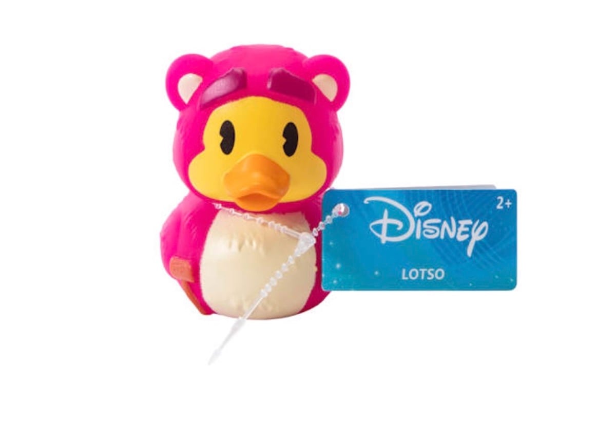 A rubber duck toy dressed as Lotso from Disney, with a pink bear costume and a blue tag labeled "Disney LOTSO 2+.