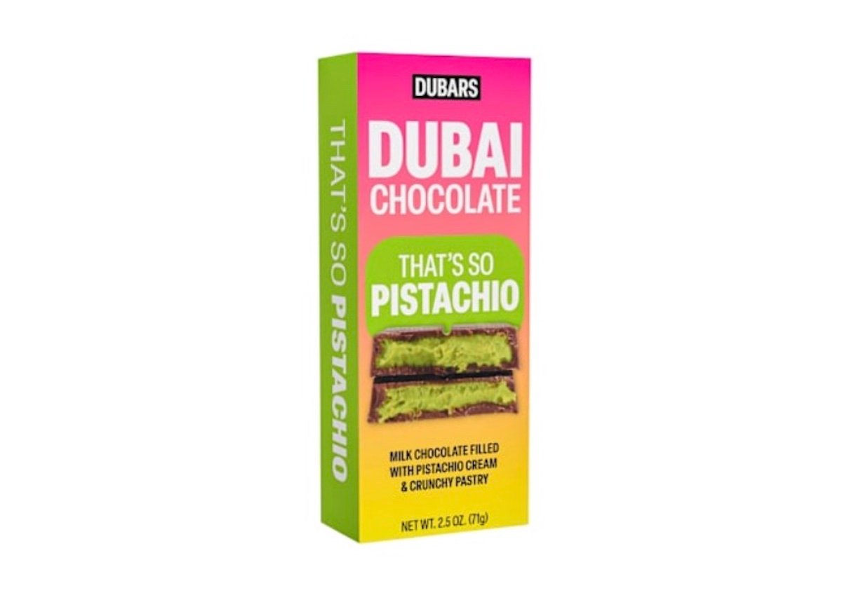 A box of Dubars Dubai Chocolate, labeled "That's So Pistachio," features an image of chocolate filled with pistachio cream and pastry. The box is pink, green, and yellow, and weighs 2.5 oz (71 g).