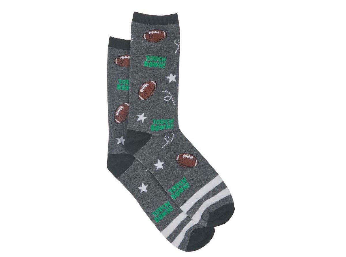 A pair of gray socks decorated with footballs, white stars, horseshoes, and the words "TOUCH DOWN" in green. The socks have white and gray stripes on the toes.