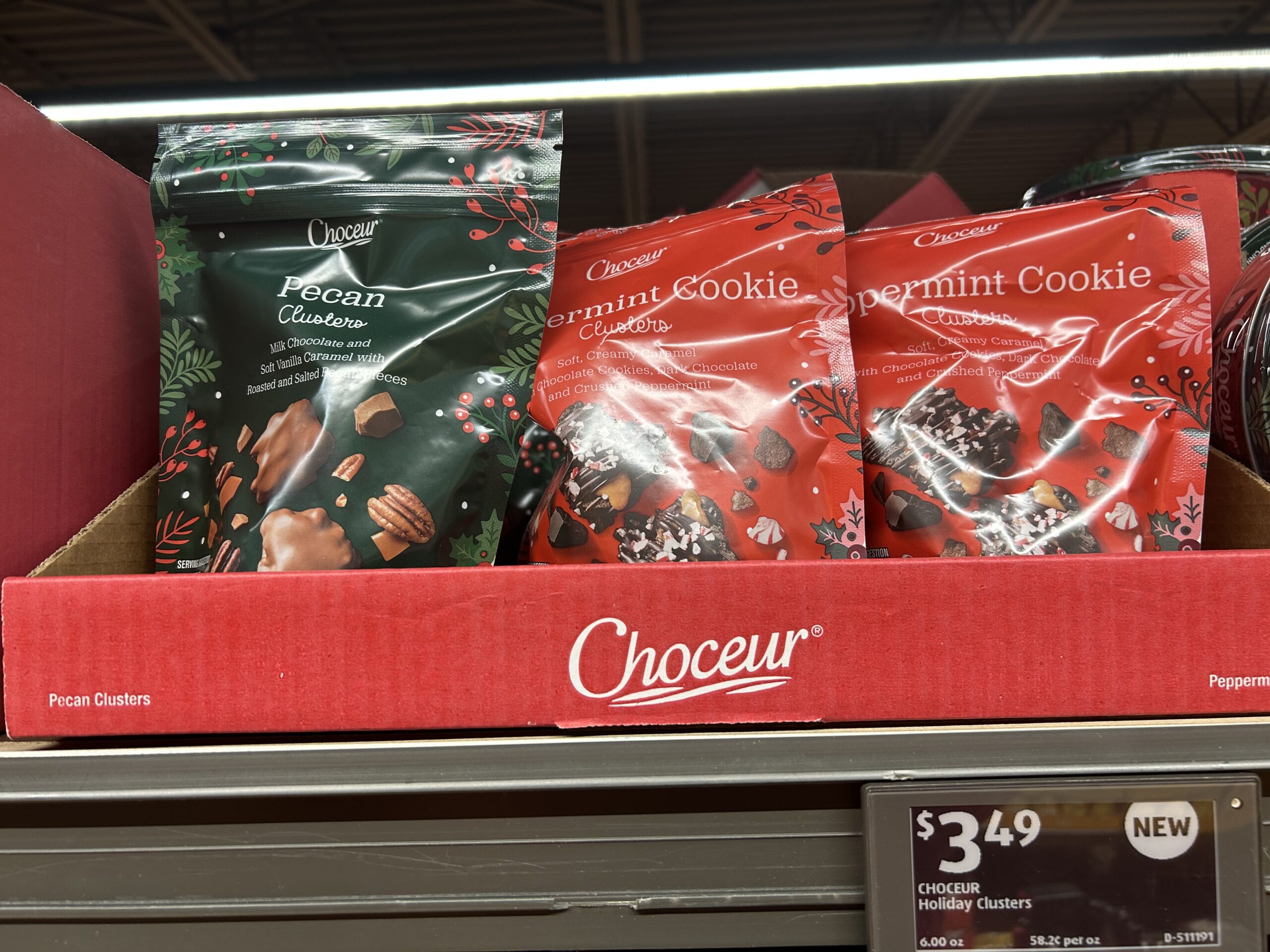 Bags of Choceur Pecan Clusters and Peppermint Cookie clusters are displayed on a store shelf. The price tag reads $3.49 and indicates the product is new.