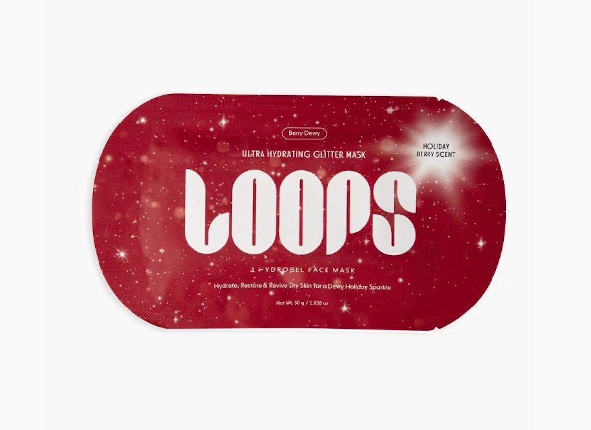 A red packet of Loops Ultra Hydrating Glitter Mask with white text and a sparkling background. It is labeled "Berry Dewy" and "Holiday Berry Scent" and designed to hydrate, restore, and revive dry skin.