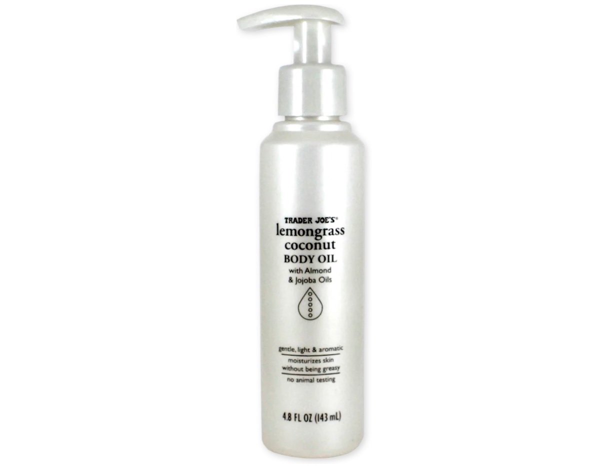 A silver bottle of Trader Joe's Lemongrass Coconut Body Oil with a pump dispenser, containing 4.8 fl oz (143 ml). The label highlights almond and jojoba oils and states it is gentle, moisturizing, and non-greasy.