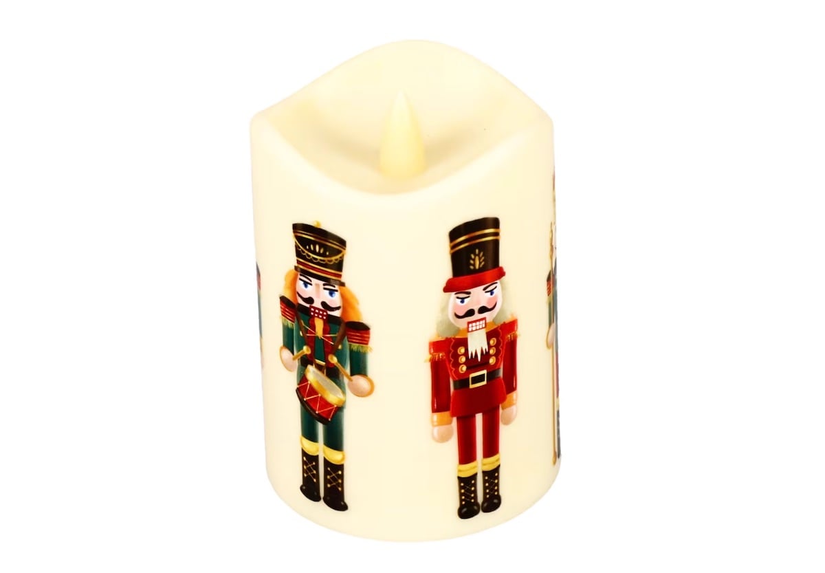 A cream-colored LED candle decorated with illustrations of toy soldiers in red and green uniforms, set against a white background.