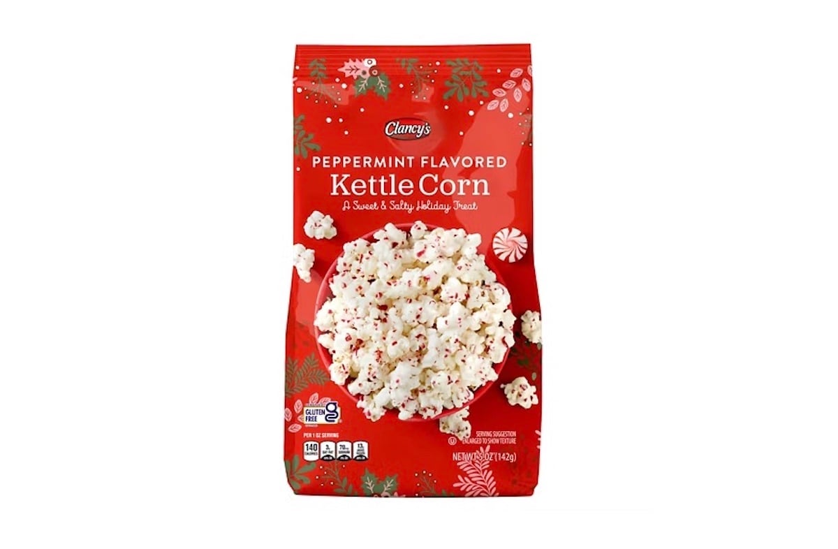 A red bag of Clancy’s Peppermint Flavored Kettle Corn with holiday-themed designs, featuring an image of popcorn sprinkled with peppermint bits. The bag is labeled “A Sweet & Salty Holiday Treat.”