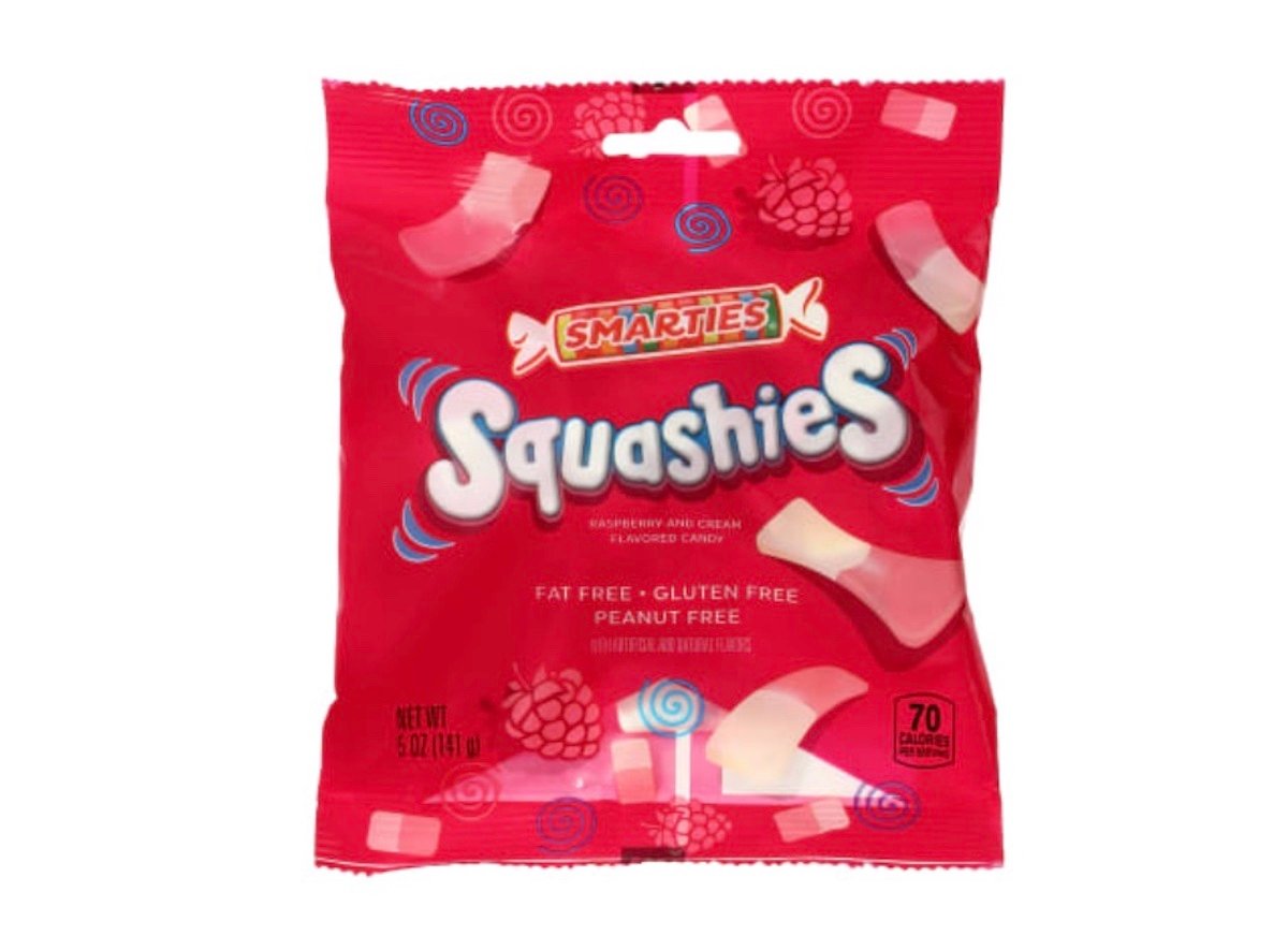 A red bag of Smarties Squashies candy featuring raspberry and cream flavors. The bag highlights that the candy is fat free, gluten free, and peanut free. The package contains 5 oz and 70 calories per serving.