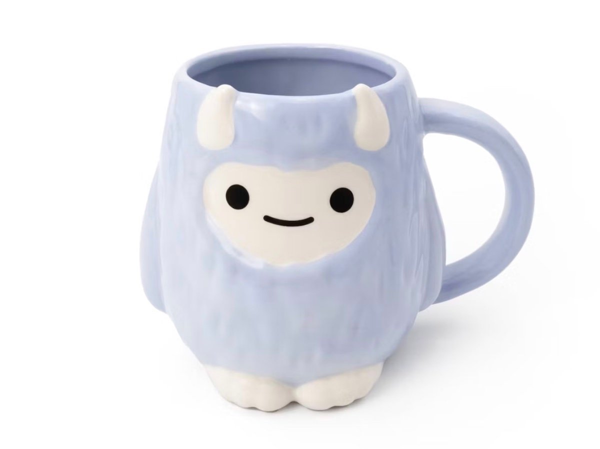 A light purple ceramic mug shaped like a cute cartoon yeti with white horns, a smiling face, and small feet at the base, against a white background.