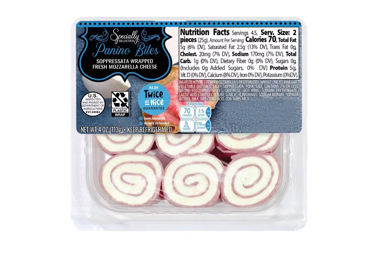 A package of Specialty Selected Panino Bites, showing spiral pieces of mozzarella cheese wrapped with soppressata. The nutrition facts label and product branding are visible on the clear plastic container.
