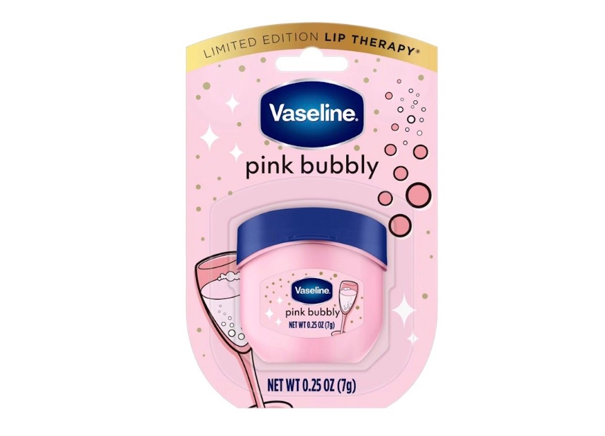 A package of Vaseline Limited Edition Lip Therapy in the "pink bubbly" flavor, featuring a small pink jar with a blue lid and a pink, festive background with champagne glasses and bubbles.