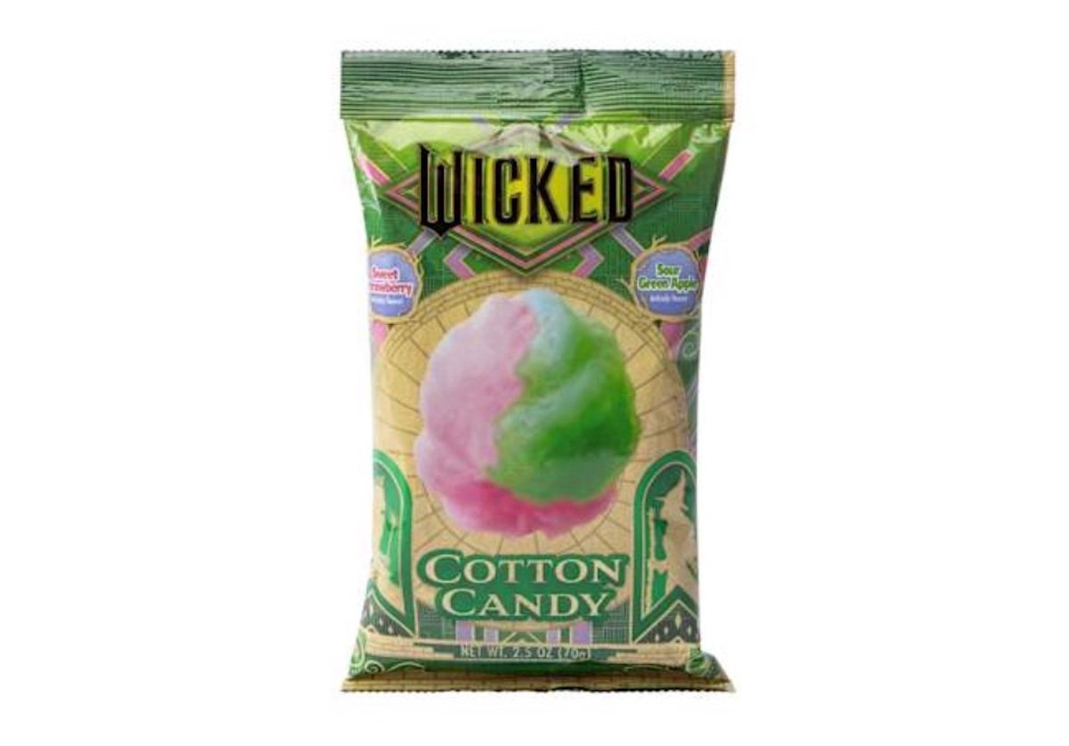 A green and beige bag labeled "Wicked" contains pink and green cotton candy. The packaging features art deco designs and text indicating "Sweet Strawberry" and "Sour Green Apple" flavors.