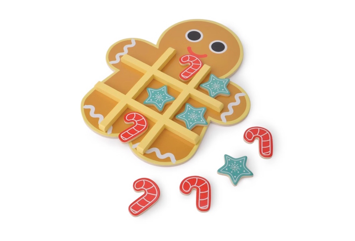 A gingerbread man-shaped tic-tac-toe board with candy cane and star pieces, some placed on the board and some scattered beside it, all on a white background.