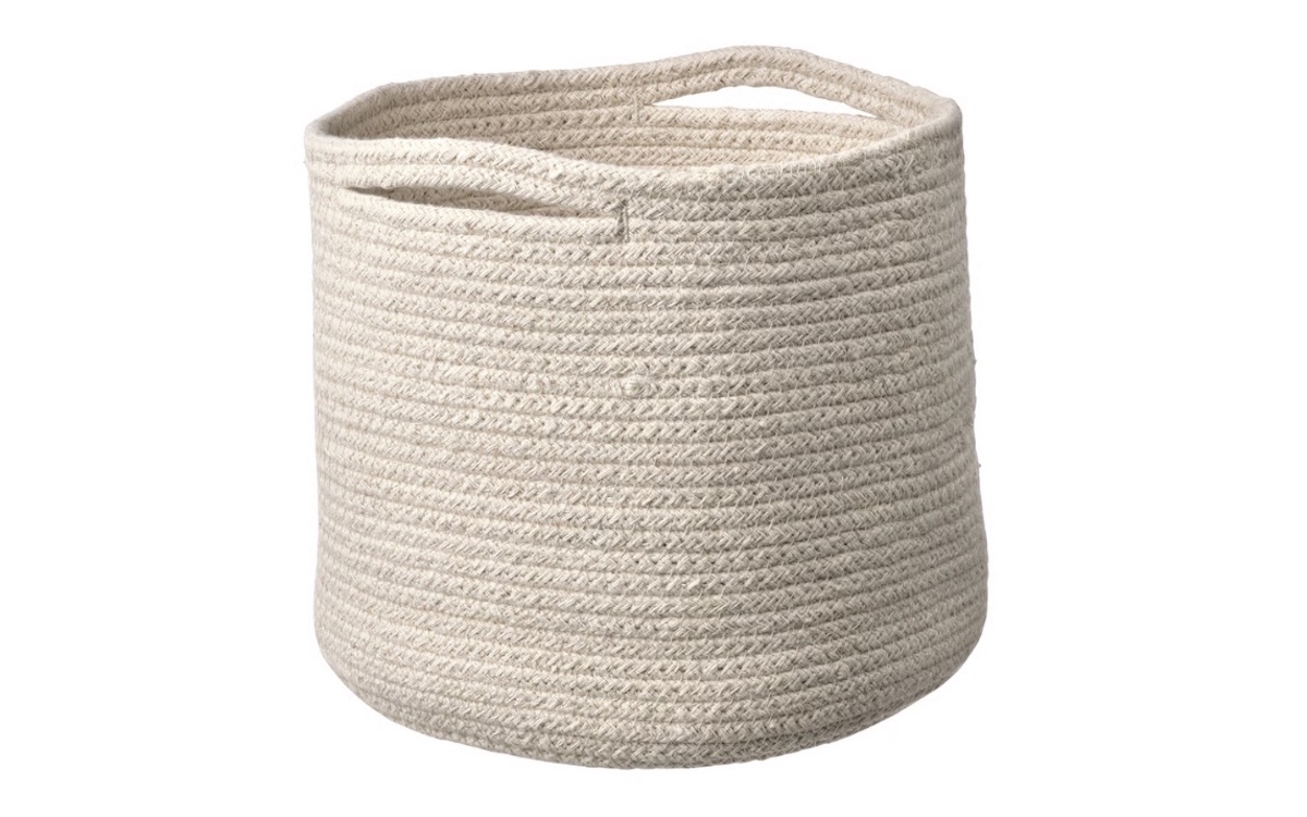 A round, cream-colored woven storage basket with two handle openings near the top, displayed on a white background.