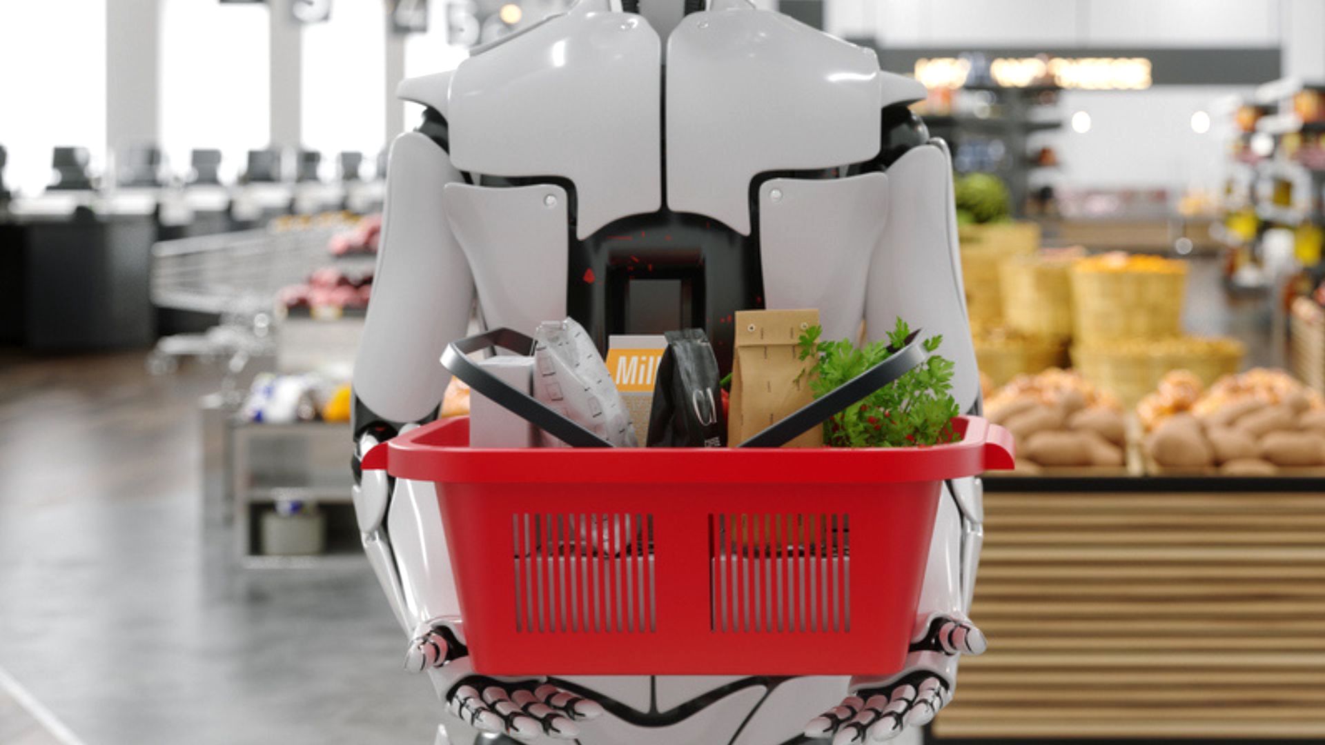 A humanoid robot holding a red shopping basket filled with groceries in a supermarket, with shelves of bread and produce in the background.