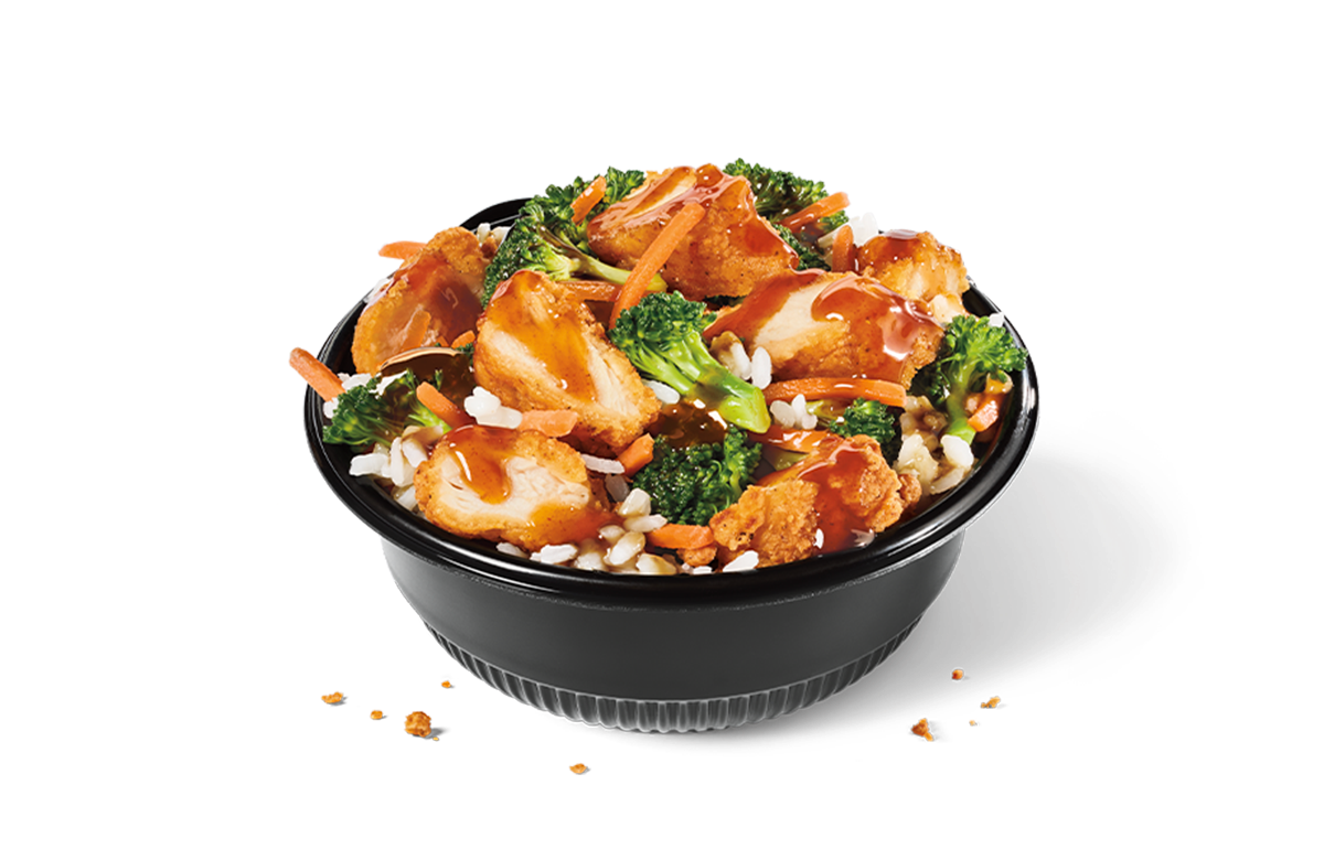 A black bowl from the new fast-food menu filled with white rice, broccoli, shredded carrots, and crispy breaded chicken pieces drizzled with a savory brown sauce.