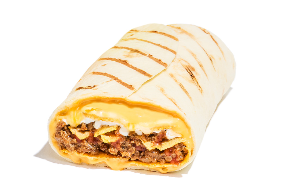 A close-up of a grilled burrito cut in half from a new fast-food menu, showing layers of seasoned ground beef, nacho cheese sauce, crispy tortilla strips, and sour cream wrapped in a flour tortilla against a plain white background.