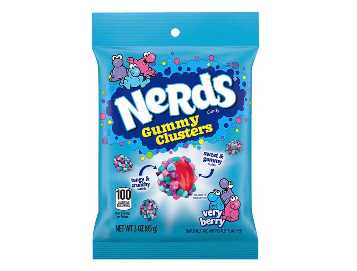 A blue bag of Nerds Gummy Clusters candy, featuring colorful cartoon Nerds characters and images of the candy. The packaging highlights sweet and gummy, tangy and crunchy textures, with a "Very Berry" flavor label.