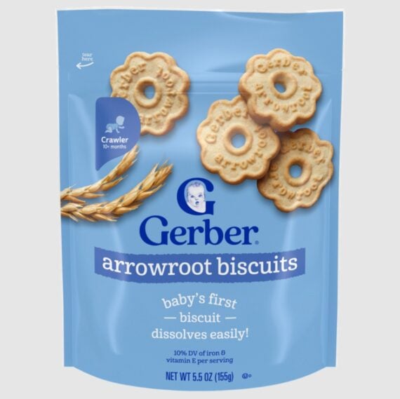 A blue package of Gerber arrowroot biscuits featuring images of round, flower-shaped biscuits, wheat stalks, and text indicating it is for crawlers 10+ months, labeled &ldquo;baby&rsquo;s first biscuit, dissolves easily.&rdquo;