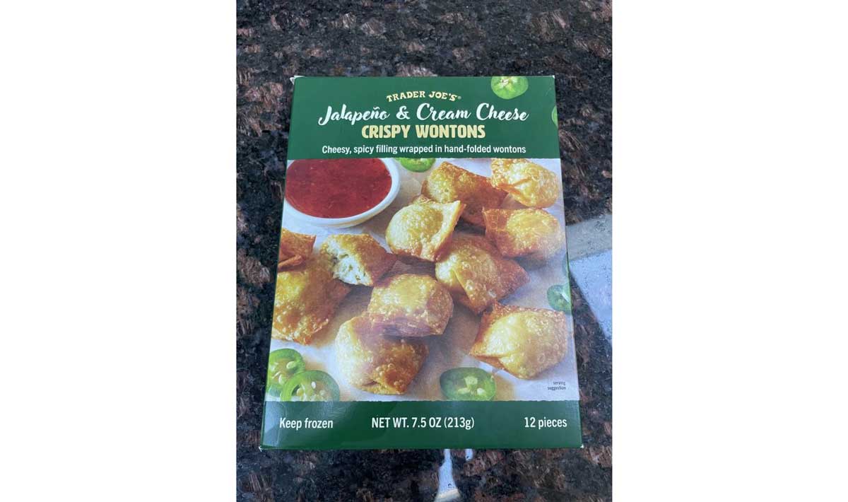 A box of Trader Joe’s Jalapeño & Cream Cheese Crispy Wontons, featuring an image of golden wontons with dipping sauce, jalapeño slices, and product details on a dark countertop.