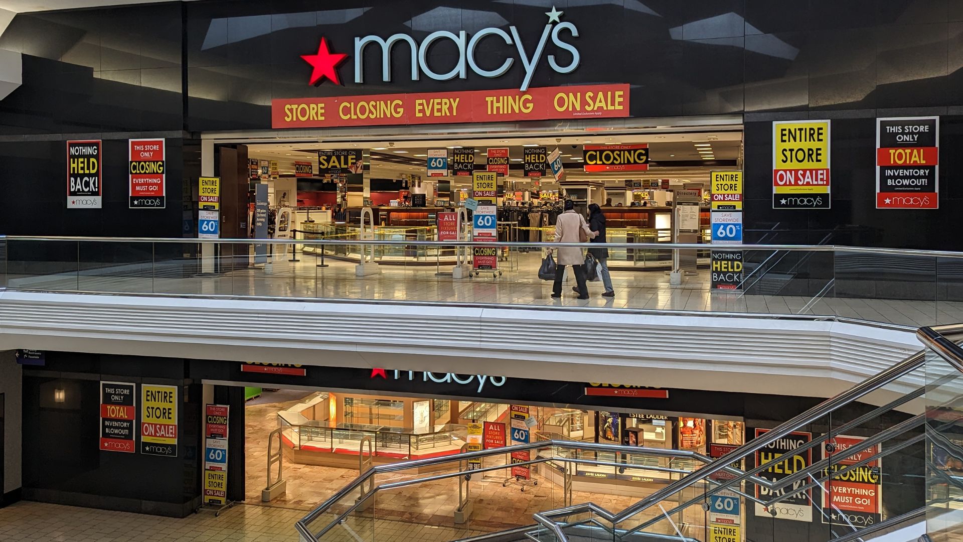 A store front with signs and people walking