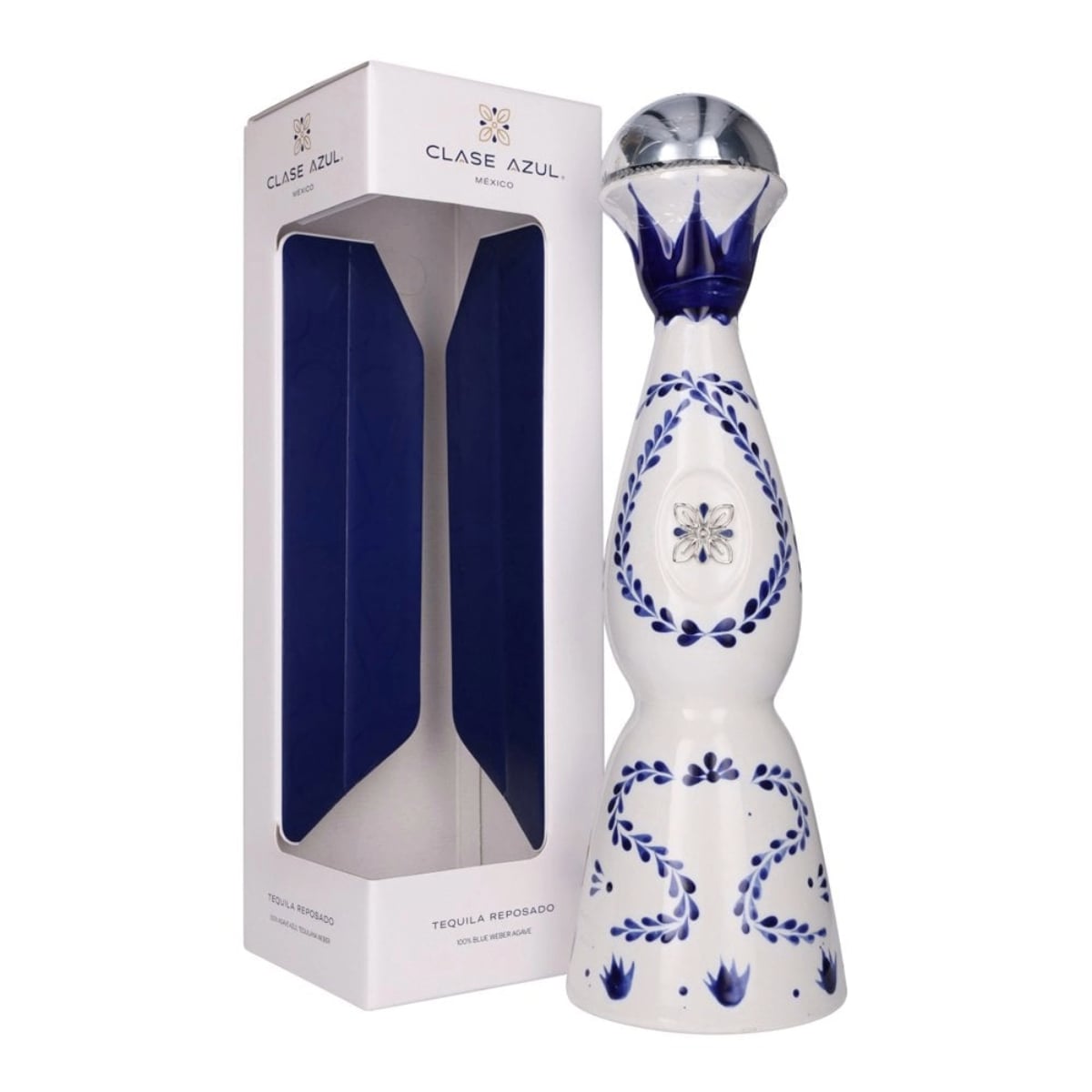 A white and blue ceramic Clase Azul tequila bottle with decorative designs stands next to its matching white and blue presentation box.