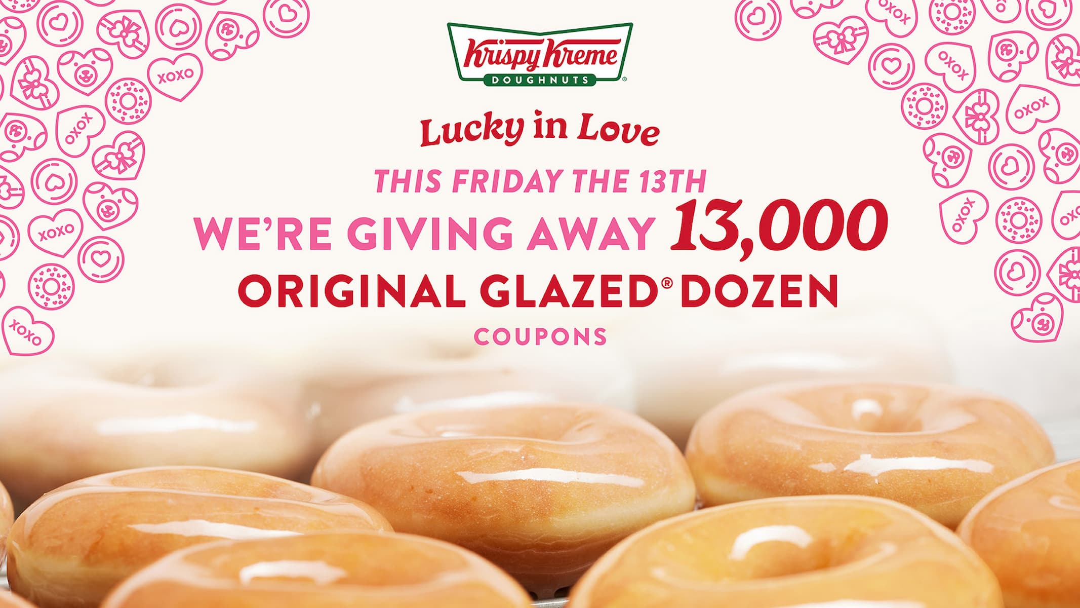 Promotional image for Krispy Kreme featuring glazed donuts and pink hearts, announcing a giveaway of 13,000 Original Glazed dozen coupons on Friday the 13th with the phrase "Lucky in Love.