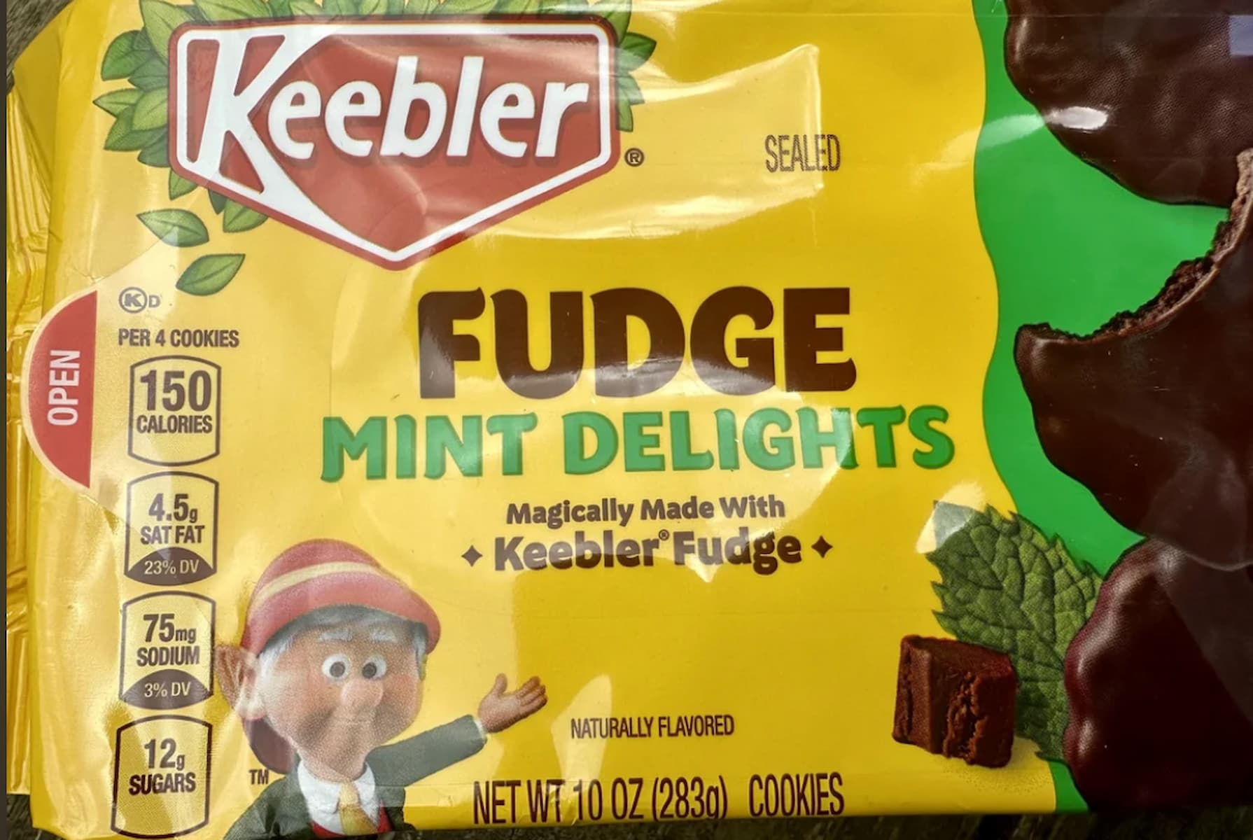 A package of Keebler Fudge Mint Delights cookies, featuring a yellow background, nutrition facts, a cartoon elf, mint leaves, and images of chocolate-covered cookies.