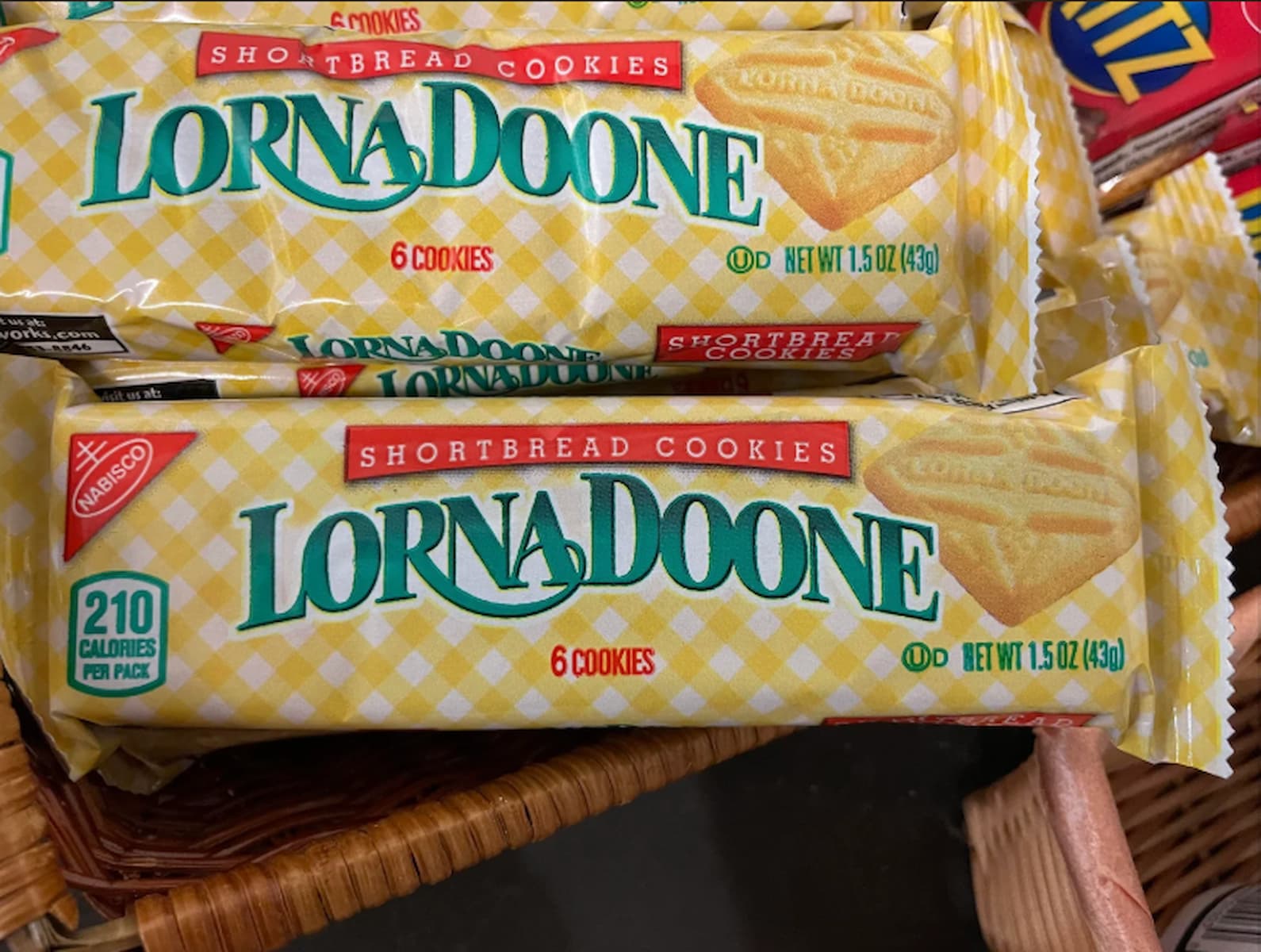 Two packages of Lorna Doone shortbread cookies, each containing six cookies, are displayed in a basket. The packaging is yellow with a checkered pattern and features the Nabisco logo.