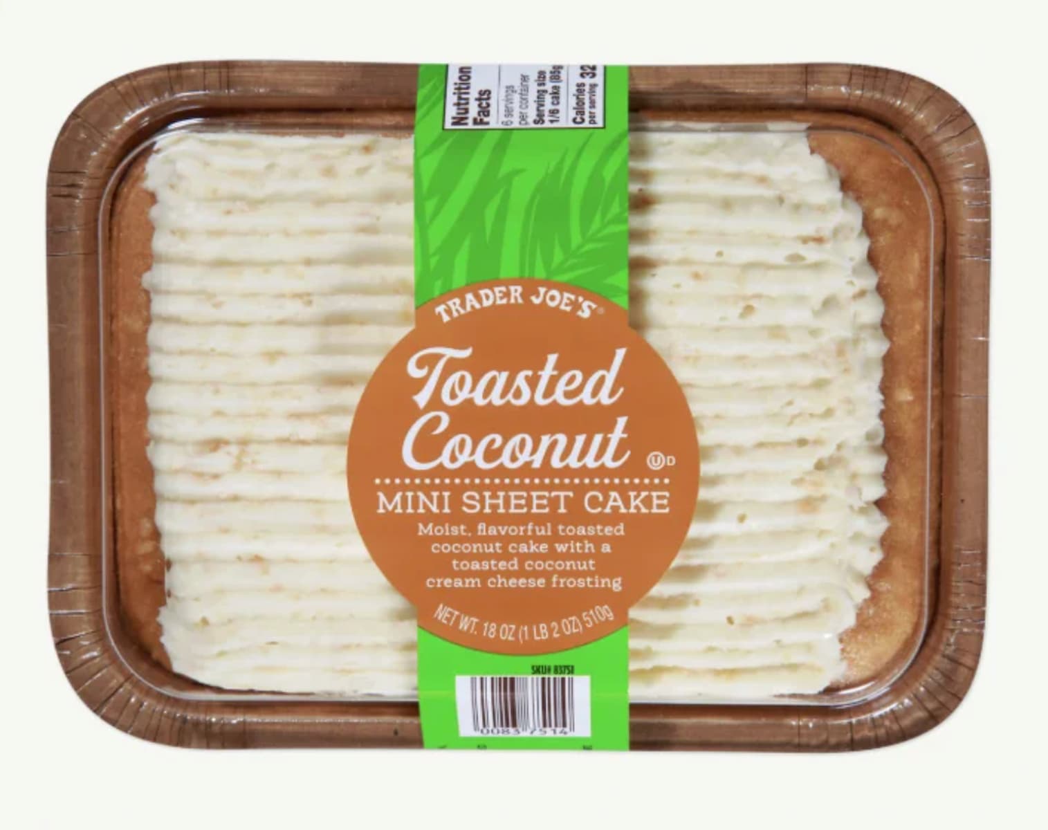 A rectangular tray of Trader Joe's Toasted Coconut Mini Sheet Cake with white frosting and a brown label in the center describing it as a coconut cake with toasted coconut cream cheese frosting.