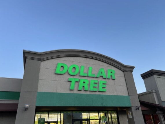 The front of a Dollar Tree store with large green letters on the sign, set against a clear blue sky.