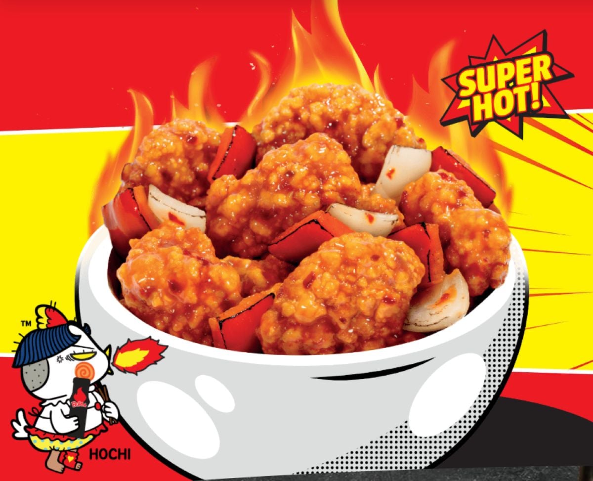 A white bowl filled with spicy, saucy fried chicken pieces, red chili slices, and onions sits against a fiery background, highlighting the new fast-food menu with "SUPER HOT!" text and a cartoon chicken holding a flaming lollipop.