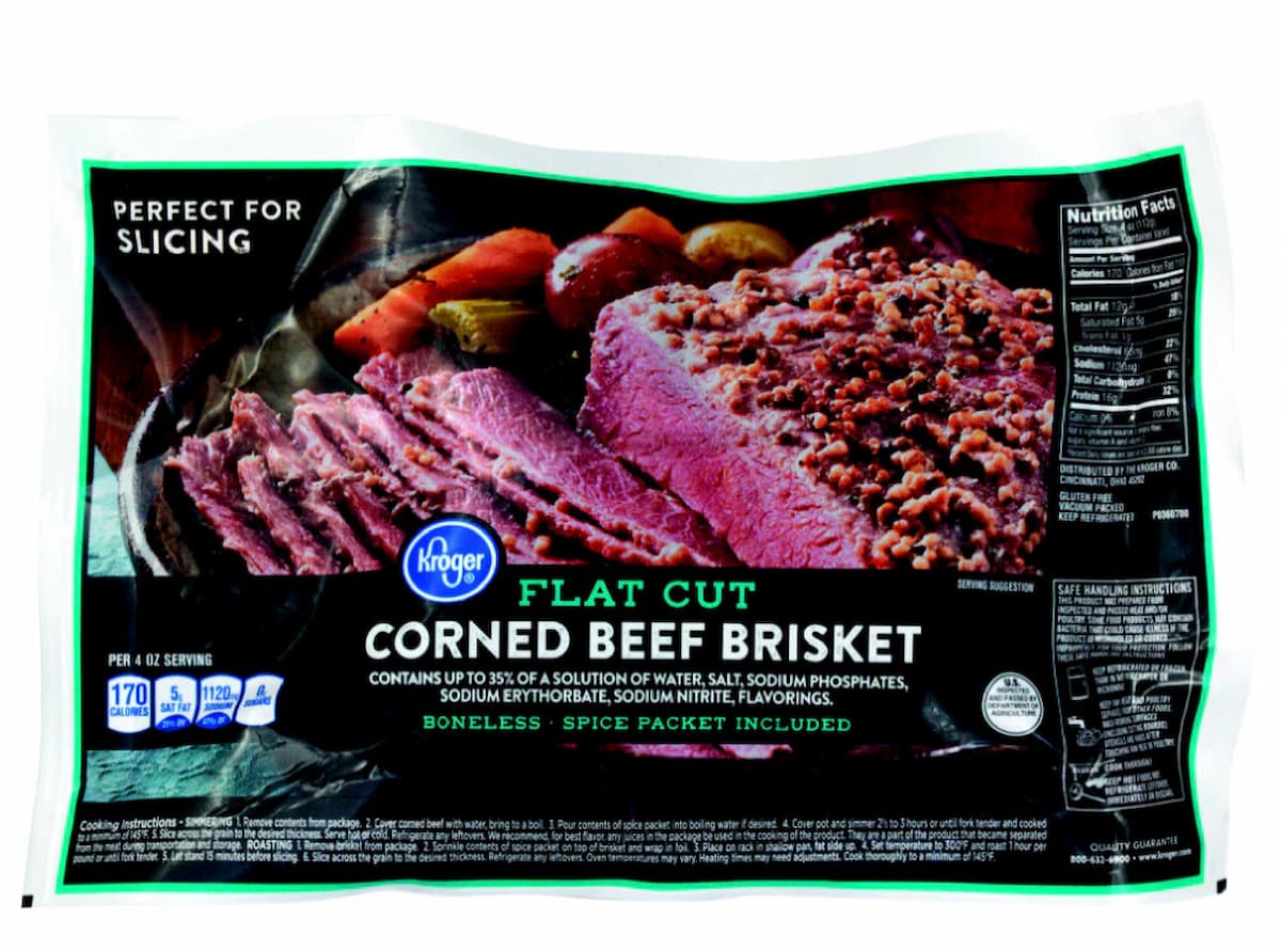 A package of Kroger Flat Cut Corned Beef Brisket, boneless, with sliced and whole brisket shown on the label. The packaging notes it includes a spice packet and is perfect for slicing. Nutrition facts are visible on the side.