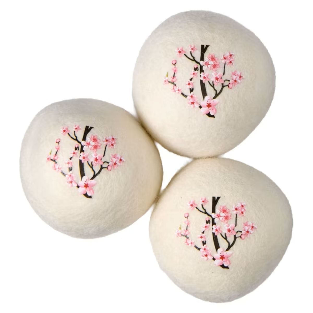 Three white wool dryer balls are arranged close together, each decorated with an illustration of a blooming cherry blossom branch featuring pink flowers and dark branches.