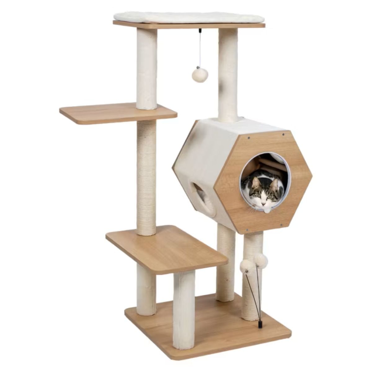 A cat sits inside a hexagonal cubby hole on a modern, multi-level wooden and carpeted cat tree with platforms, scratching posts, and hanging toys.