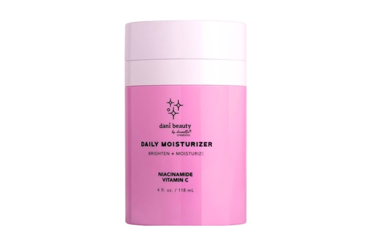A pink cylindrical container of Dani Beauty Daily Moisturizer with Niacinamide and Vitamin C, featuring bold black text and a simple star logo—an elegant addition to your collection of beauty products.