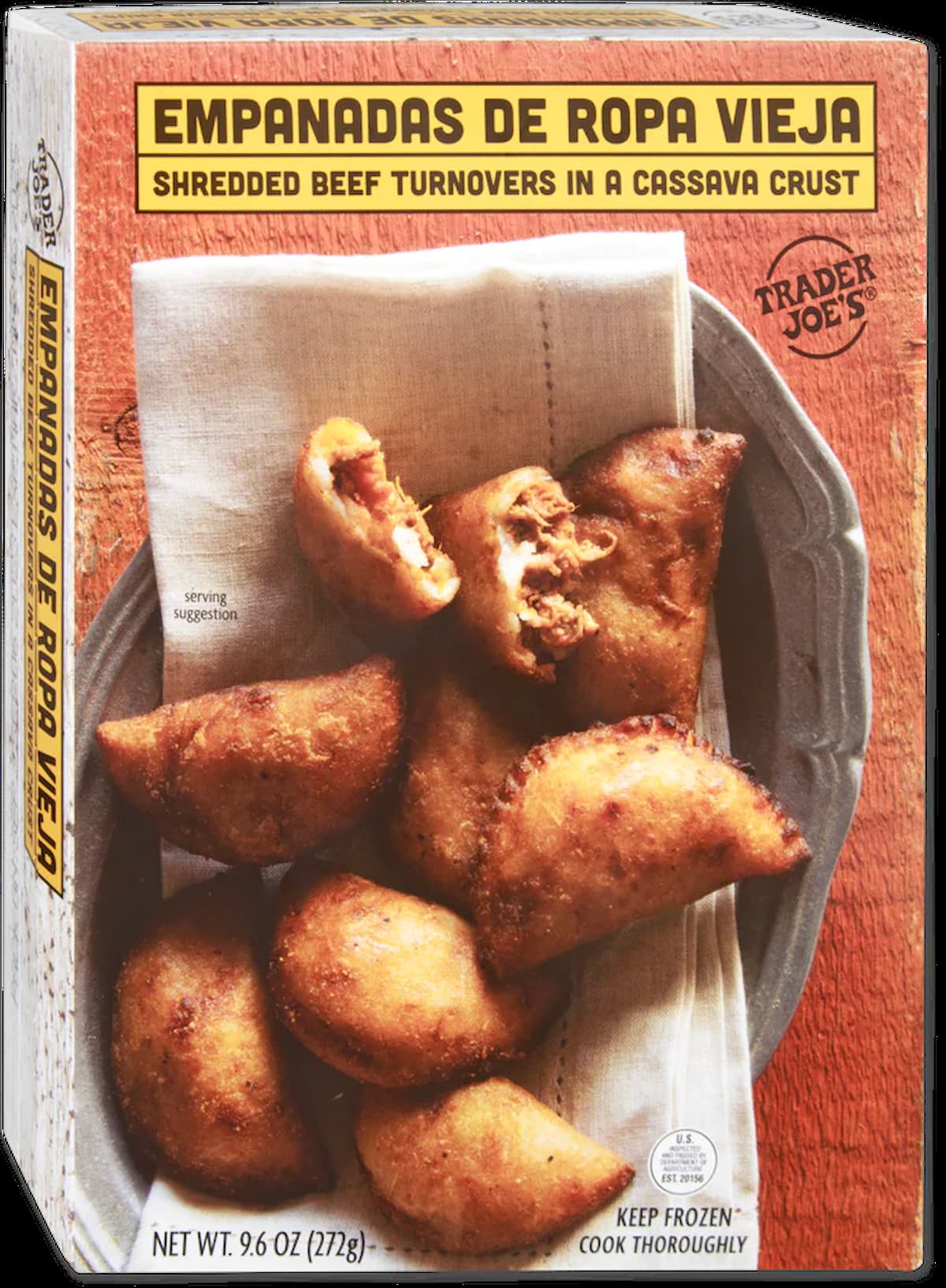 A box of Trader Joe's Empanadas de Ropa Vieja featuring shredded beef turnovers in a cassava crust, displayed on a wooden surface with several golden-brown empanadas arranged on a cloth napkin.