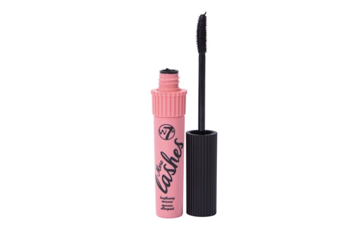 A pink tube of W7 "Lash-tastic" mascara, a standout among beauty products, with a black screw cap shown open and the mascara wand standing upright beside the tube.