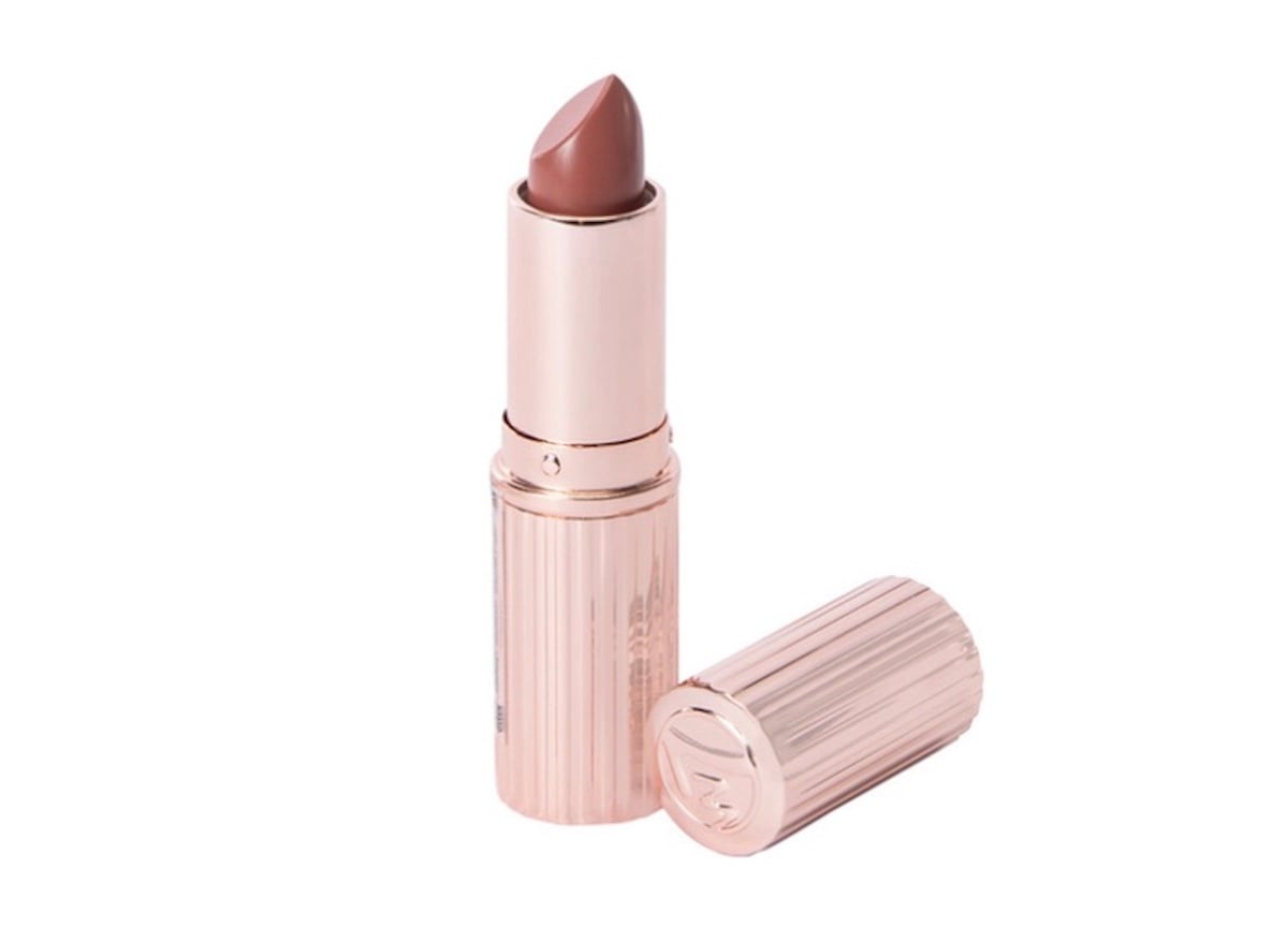 A rose gold lipstick tube with a nude pink lipstick bullet, standing upright next to its matching cap lying on its side—a stunning addition to your collection of beauty products.