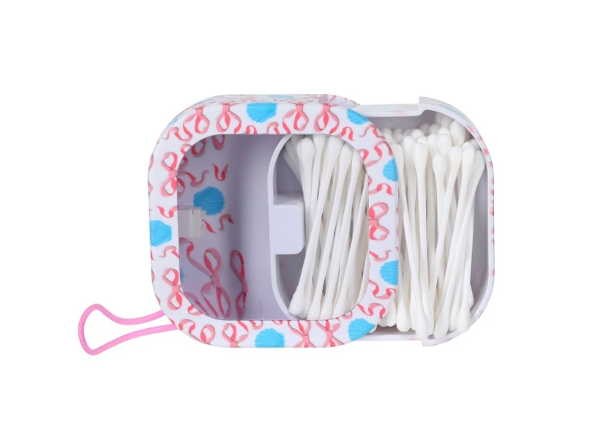 A rectangular container with a decorative pink and blue pattern, filled with white cotton swabs seen from above. This box, a great five below finds item, is partially open, revealing the neatly arranged swabs inside.