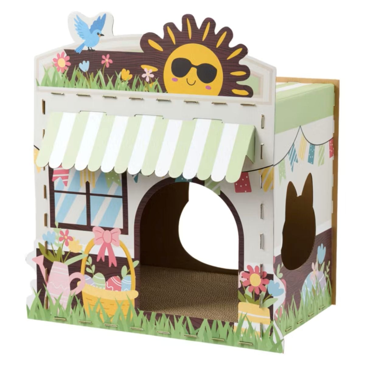 A colorful cardboard cat house decorated with flowers, a watering can, a window, a striped awning, and a smiling sun wearing sunglasses, with a blue bird perched on the roof.